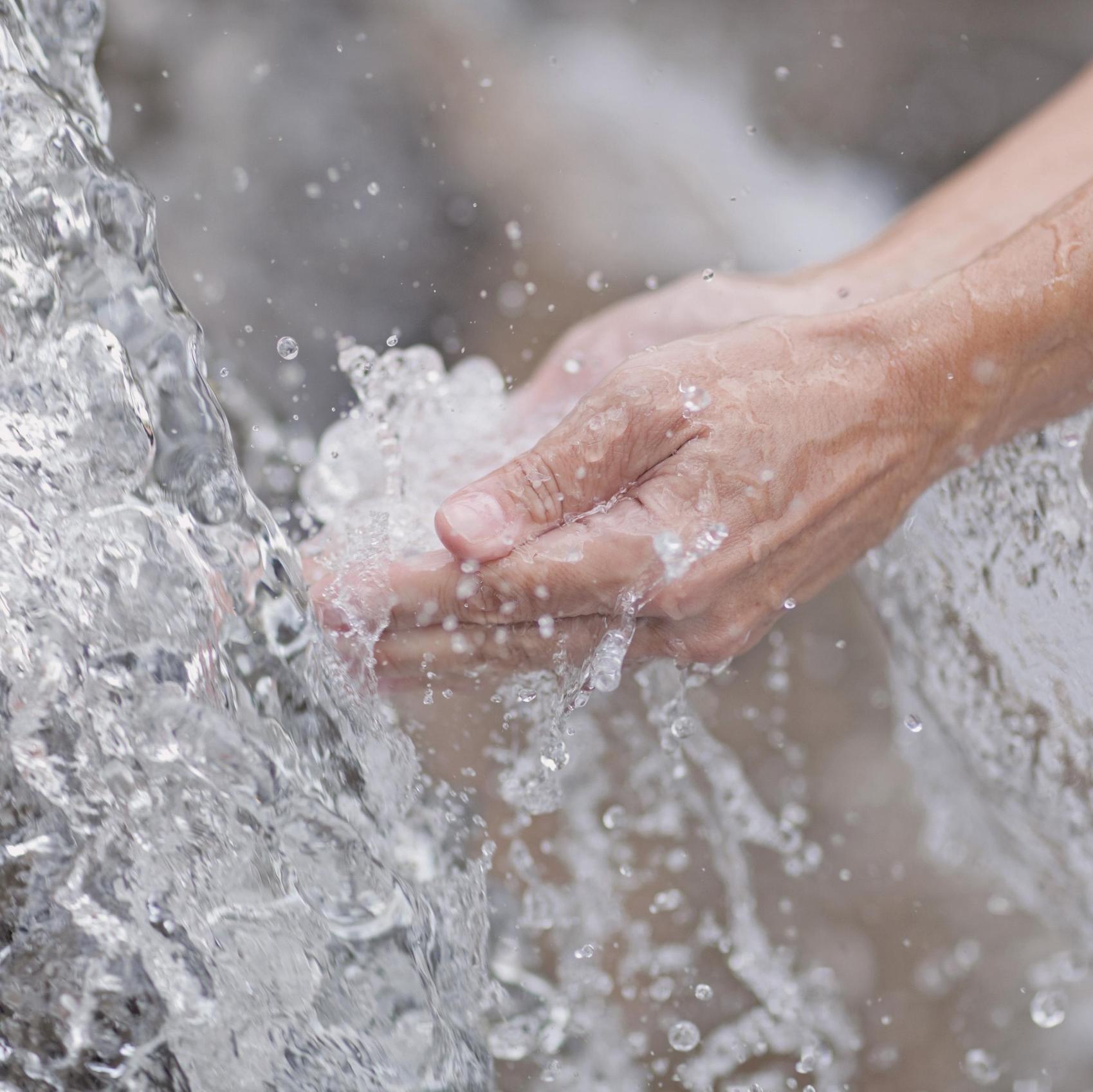 Zwei Hände im Wasserstrahl