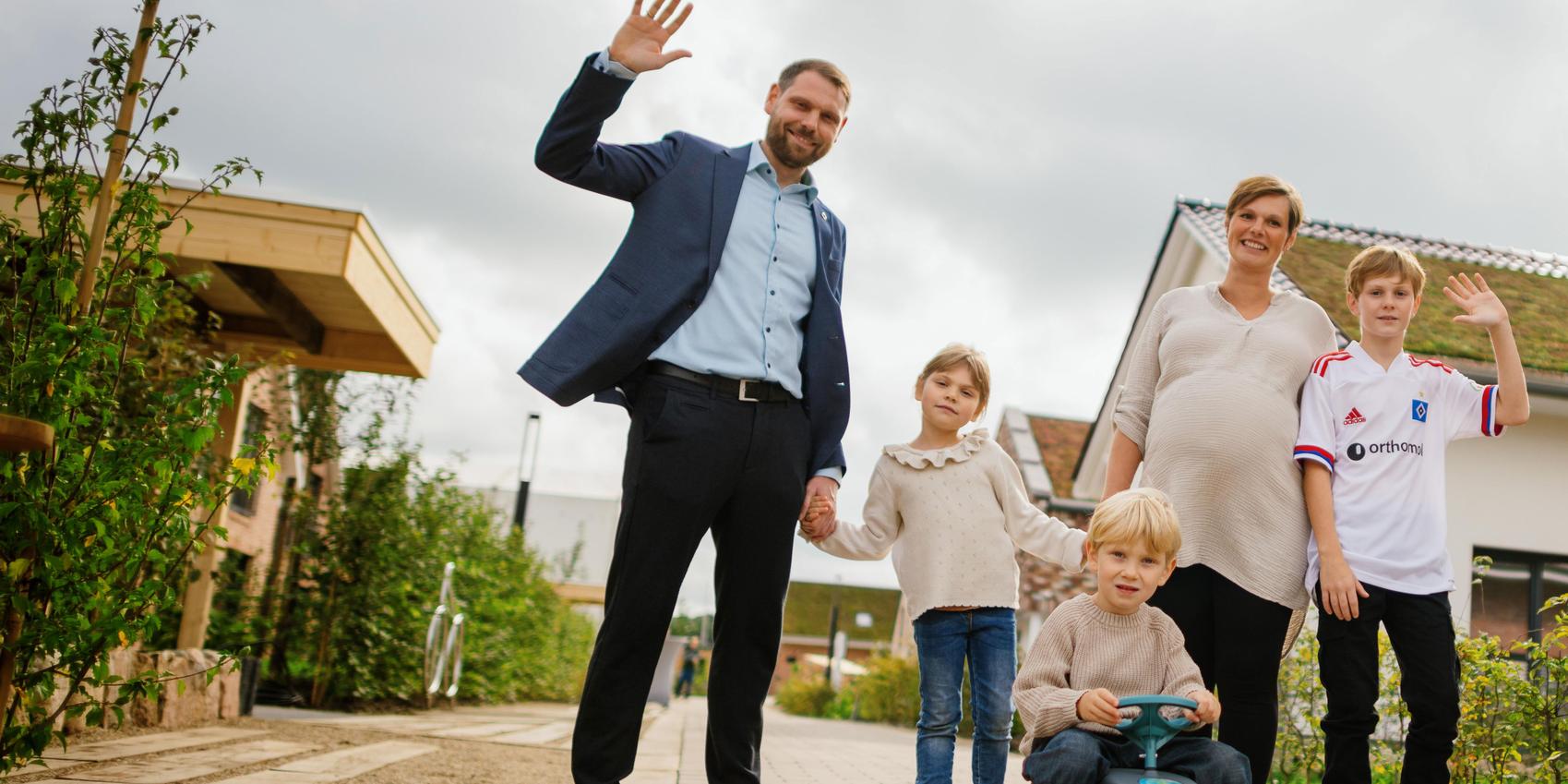 5-köpfige Familien vor Häusern