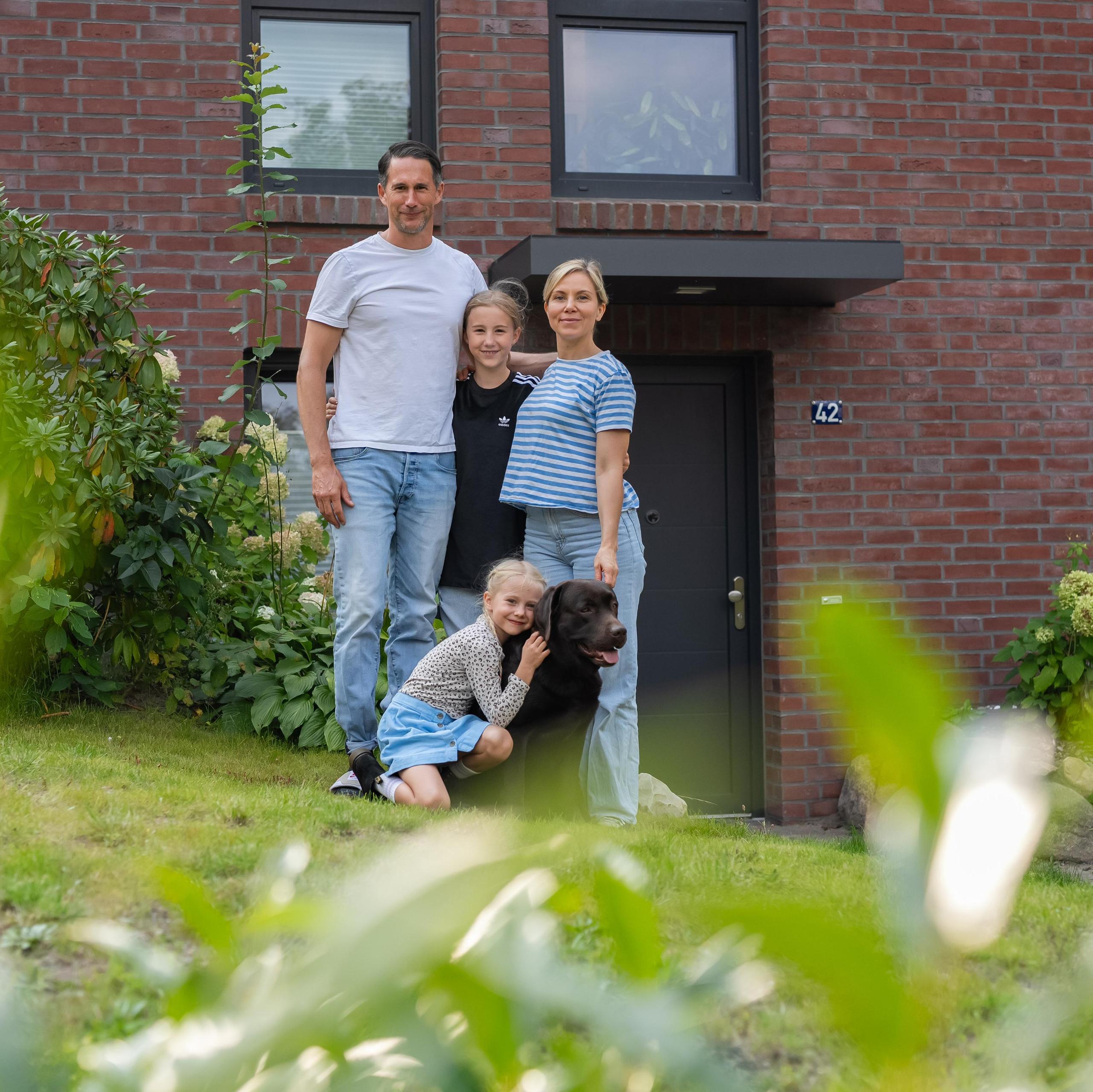 Bauherrenfamilie steht vor einem Viebrockhaus